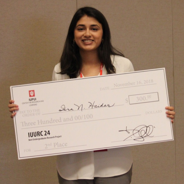 Woman holding her award check